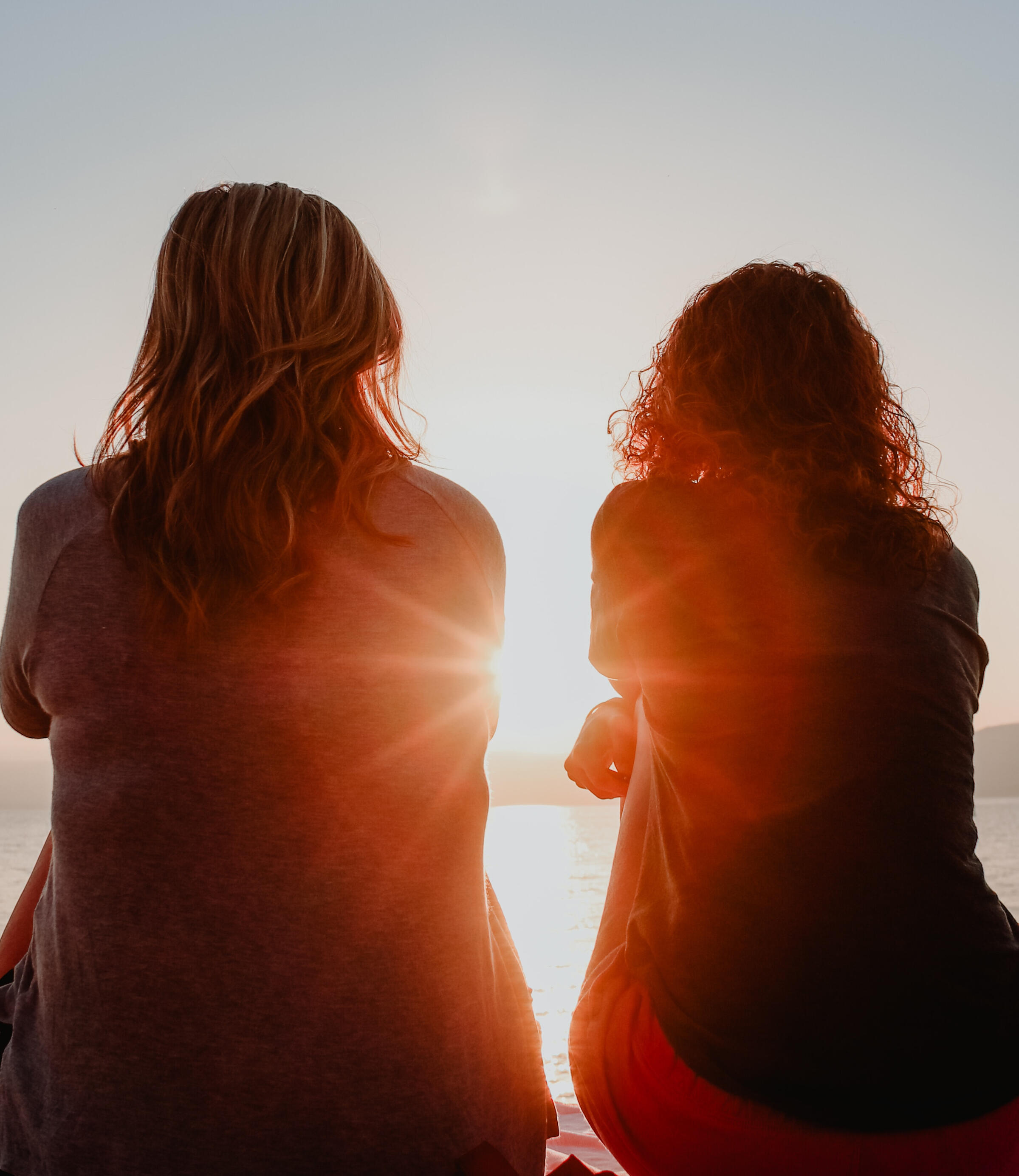 two women talking across a table from one another in front of a window viewing a city skyline